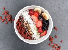 bol petit déjeuner sain avec fruits, noix de coco, baies de goji